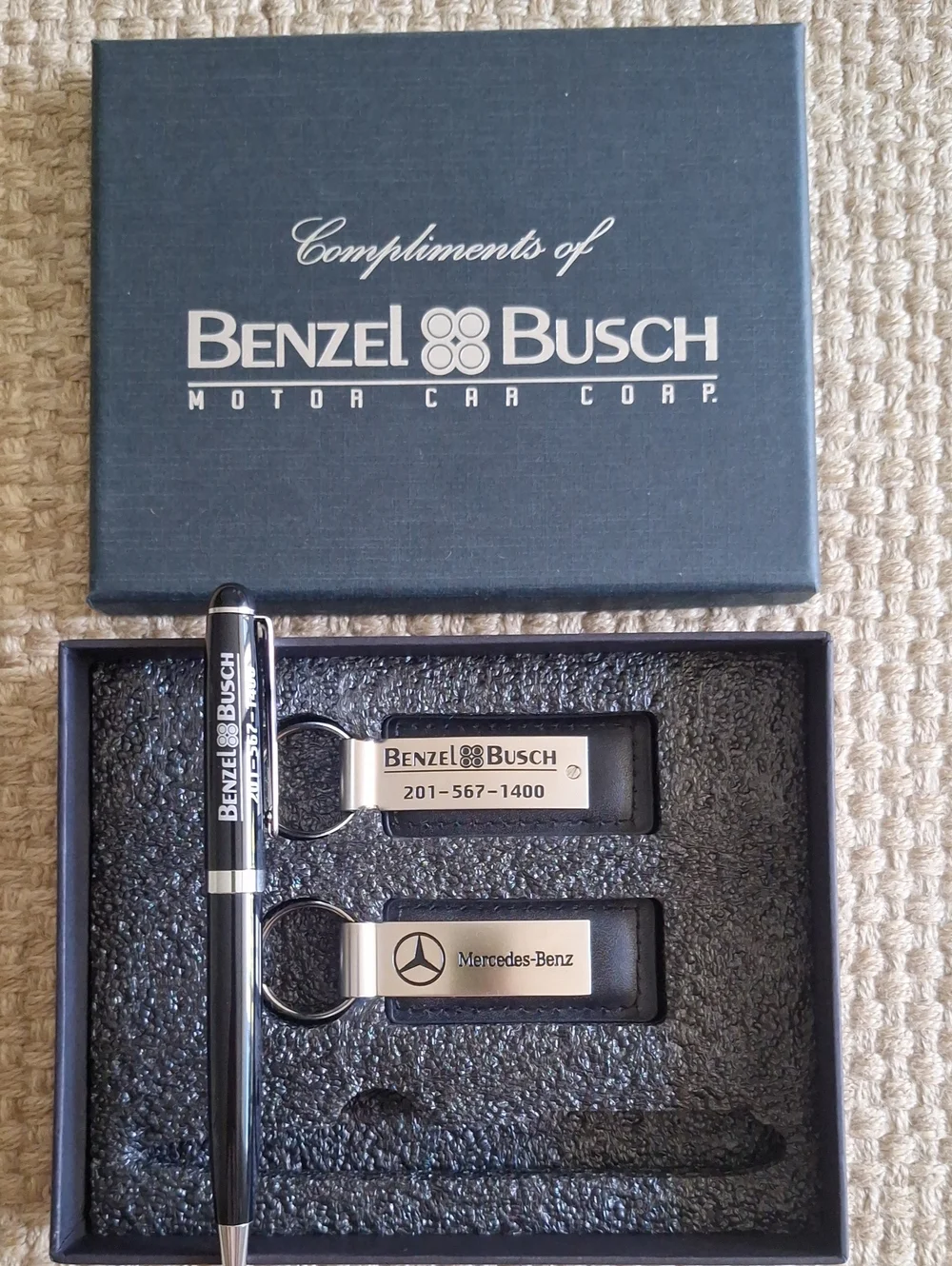 The seMercedes-Benz branded gift set featuring two keychains and a ballpoint pen